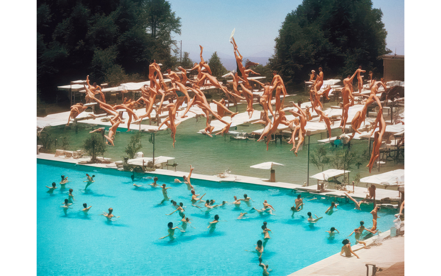 A Roope Rainisto image of a hotel pool full of swimmers, dozens of divers frozen in midair